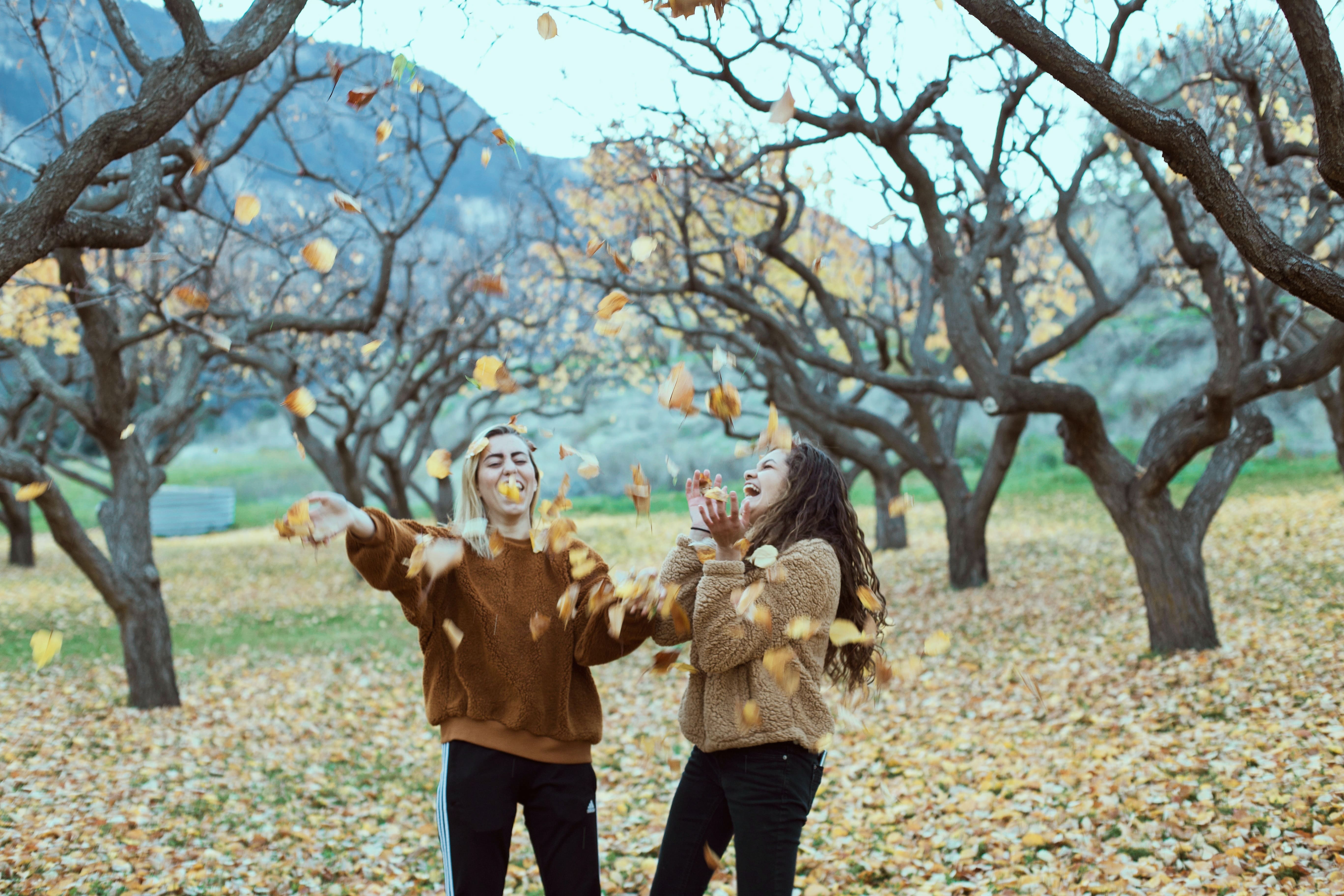 two-young-women-playing-in-the-fallen-leaves