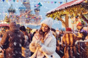 woman holding a heart-shaped candy cane at a holiday market in Moscow