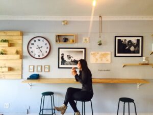 woman drinking coffee by clock showing afternoon