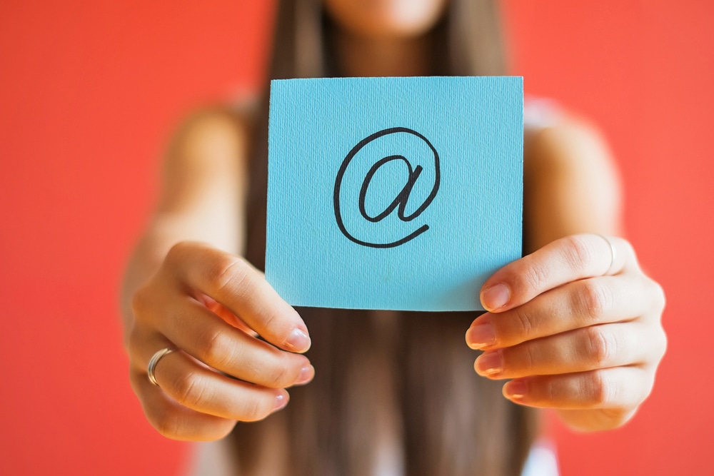 girl holding post-it with email sign