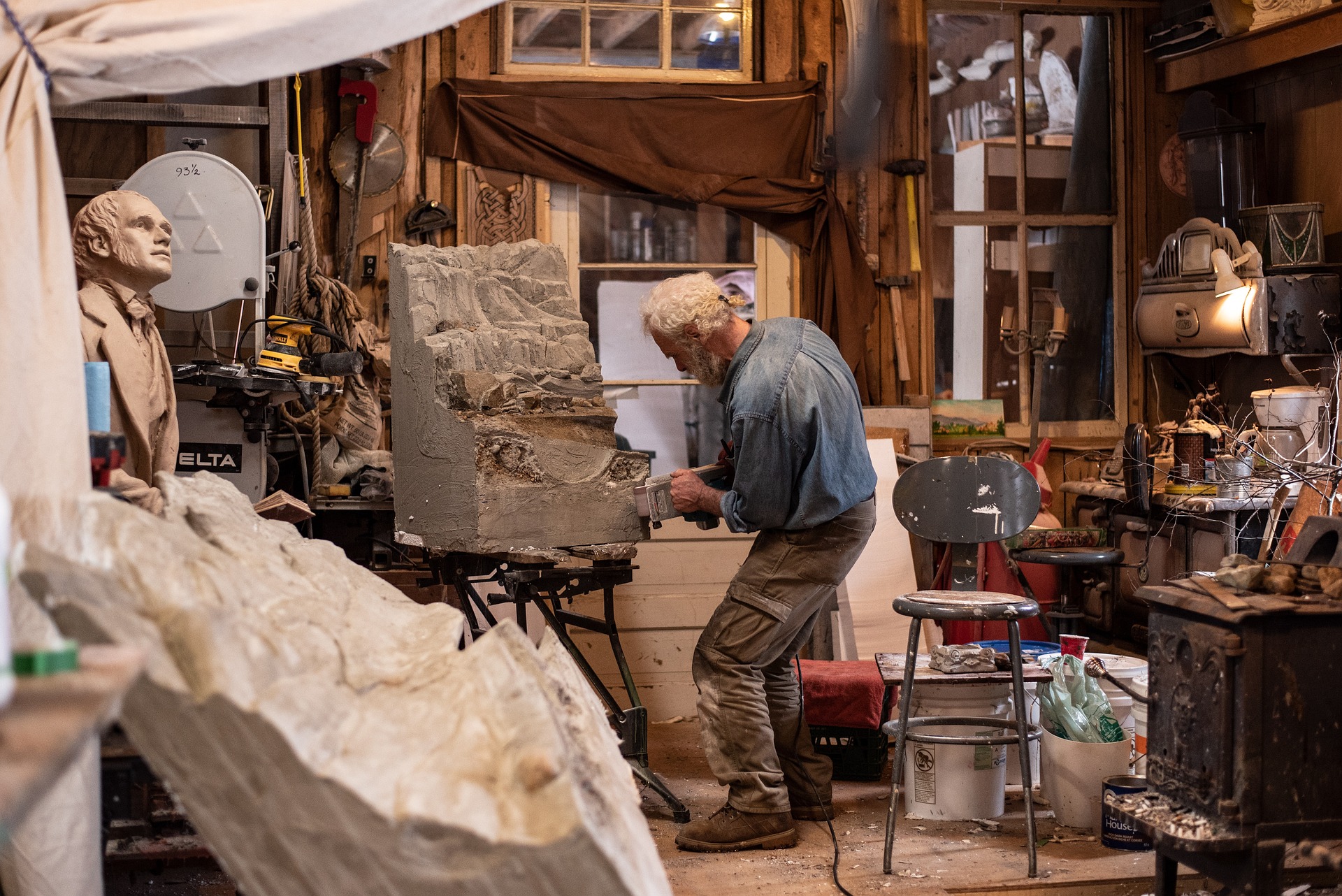 Artist working with sculptural material in a studio space.