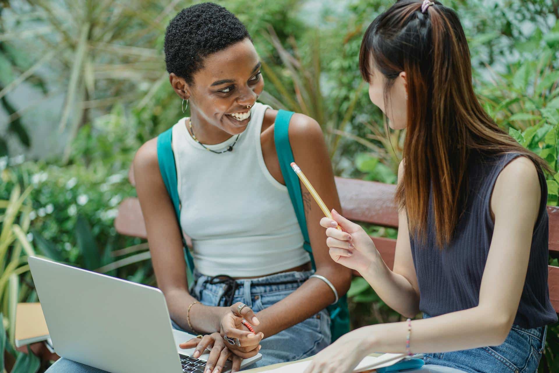 happy-young-women-working-on-assignment-project-in-park