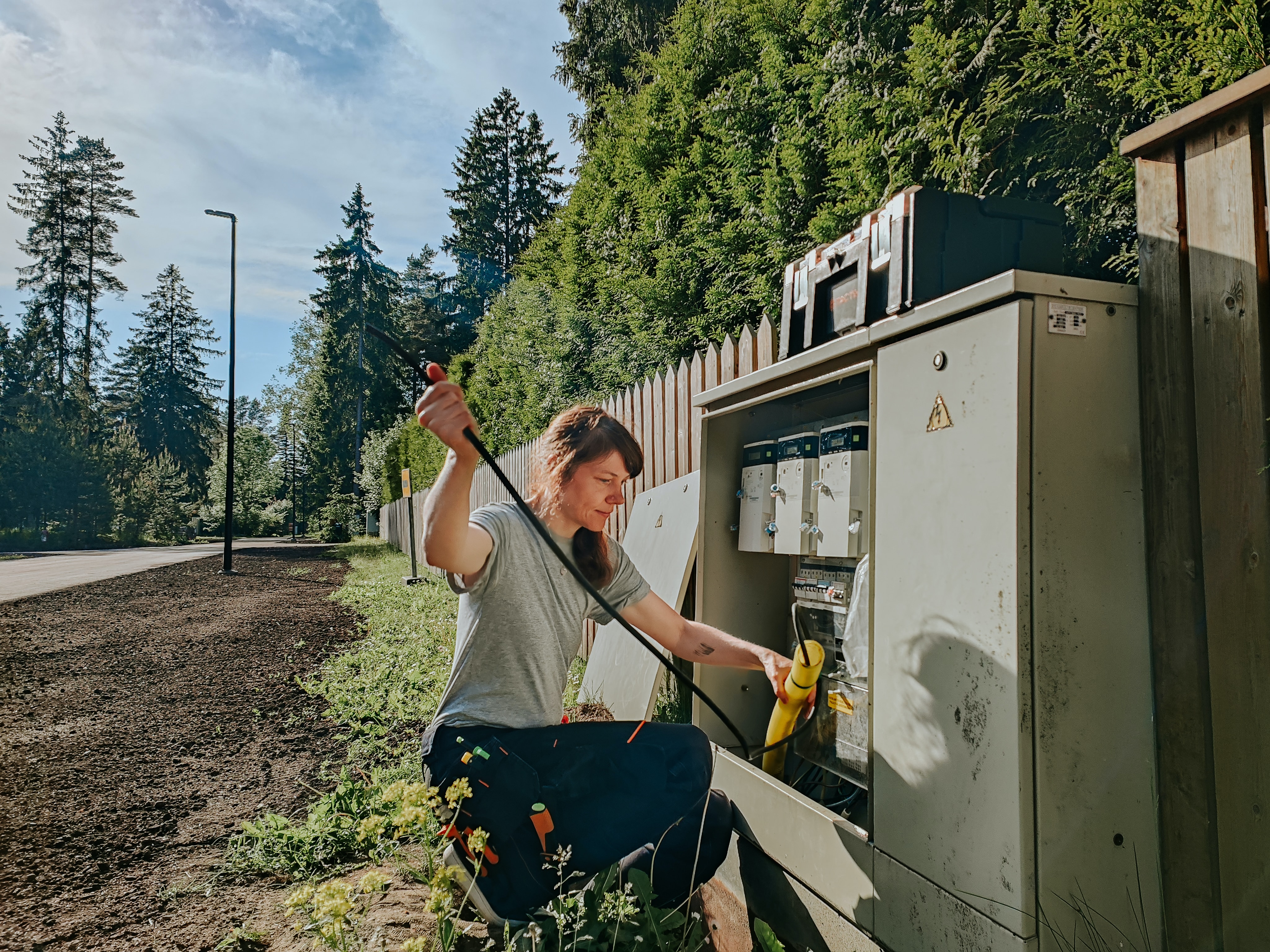 An electrician operates on a public electrical unit.