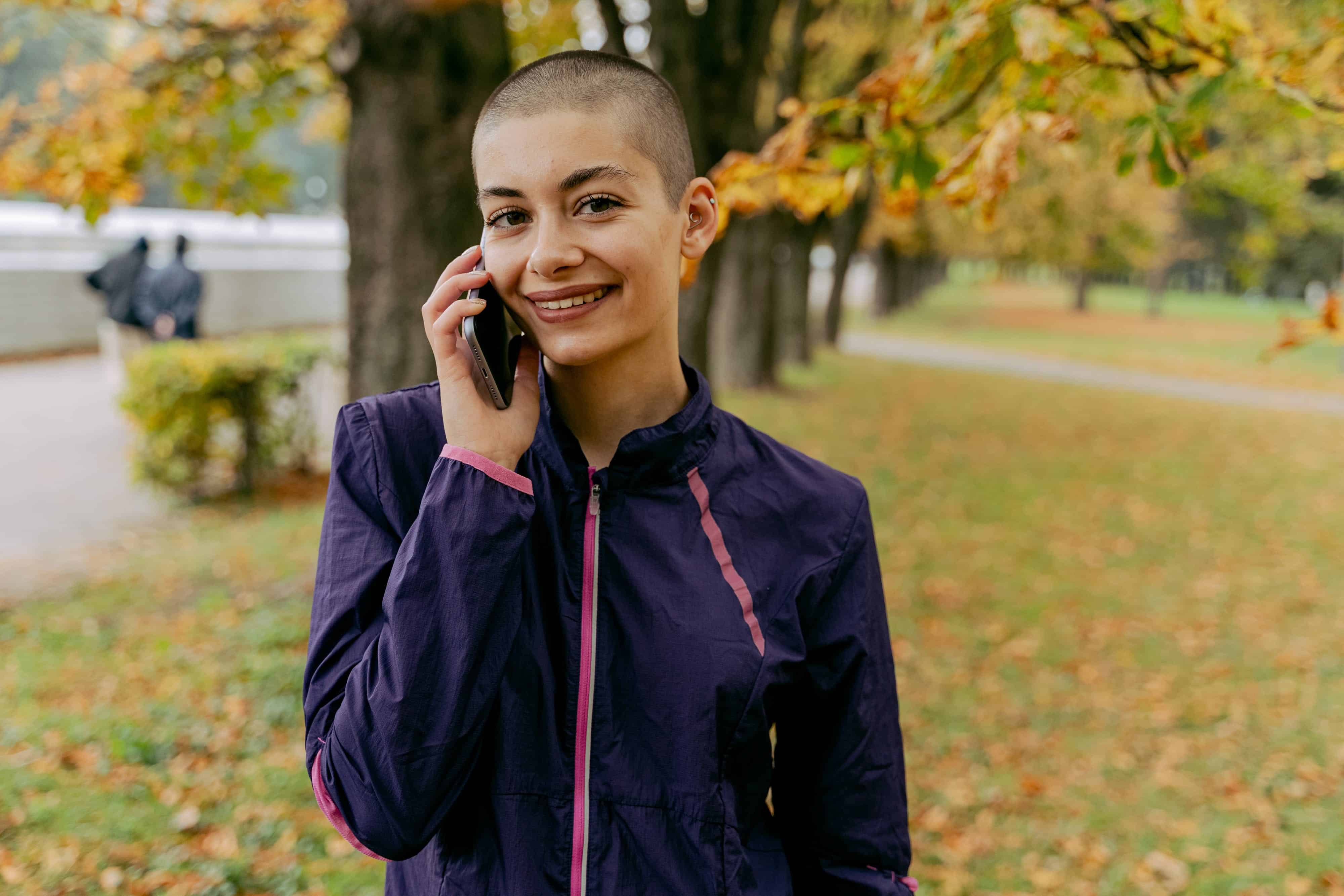 A woman talks on the telephone in a park