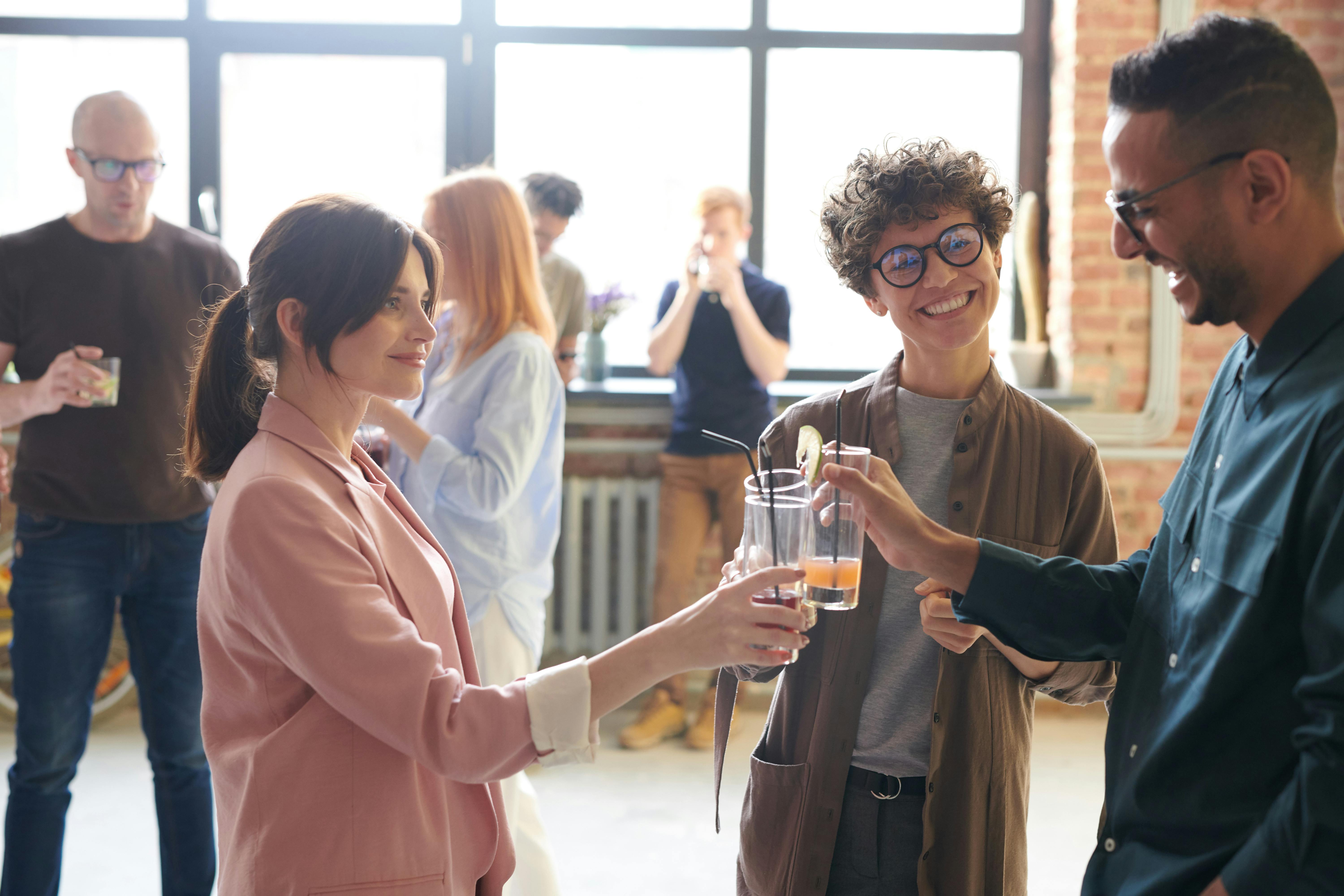 A group of people talk and clink glasses