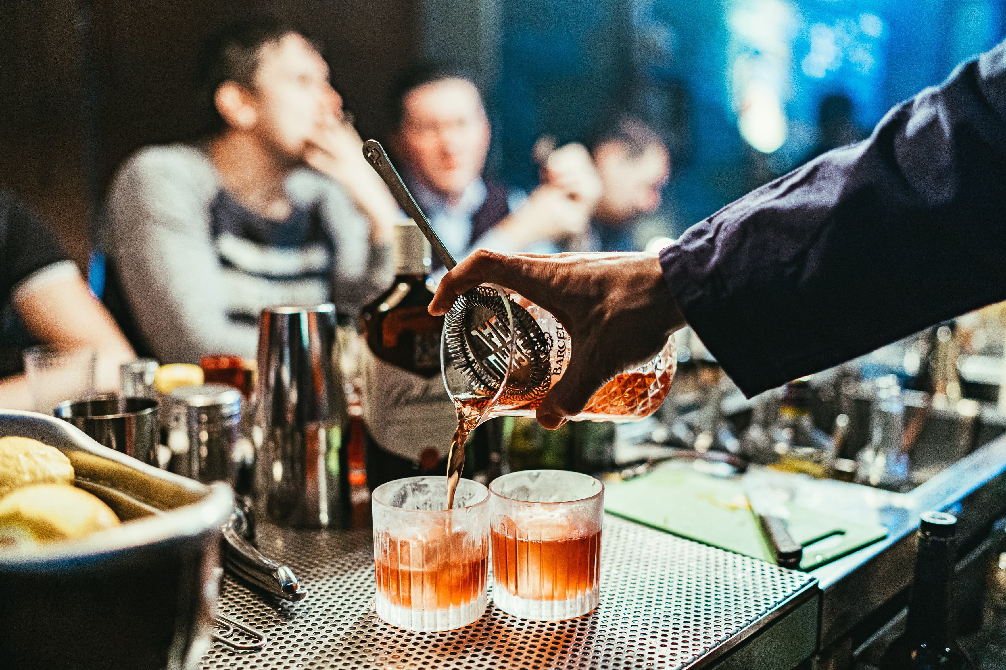 A bartender pouring a cocktail