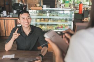 smiling customer ordering with a server at a restaurant