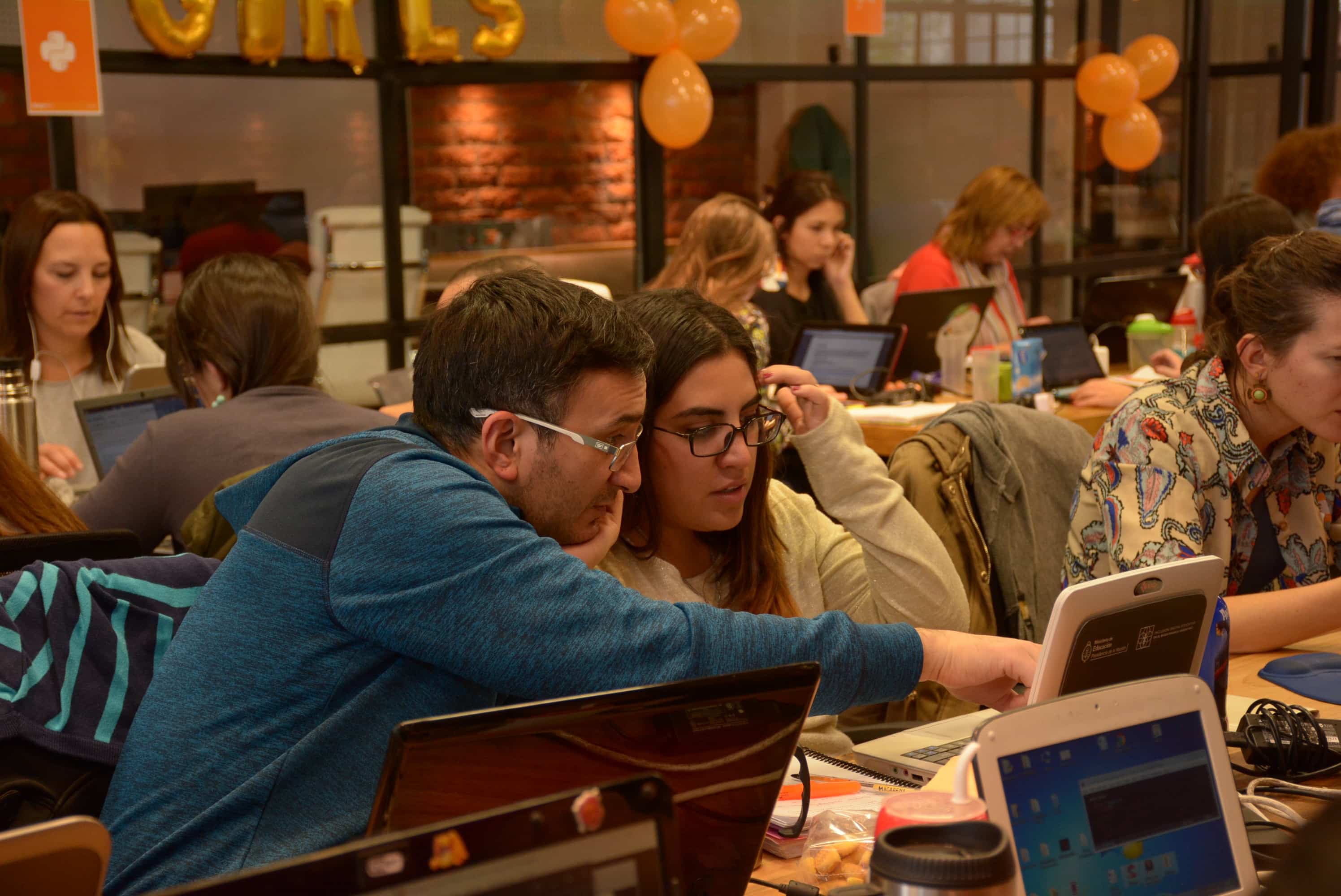 A tutor helping a student in a computer lab