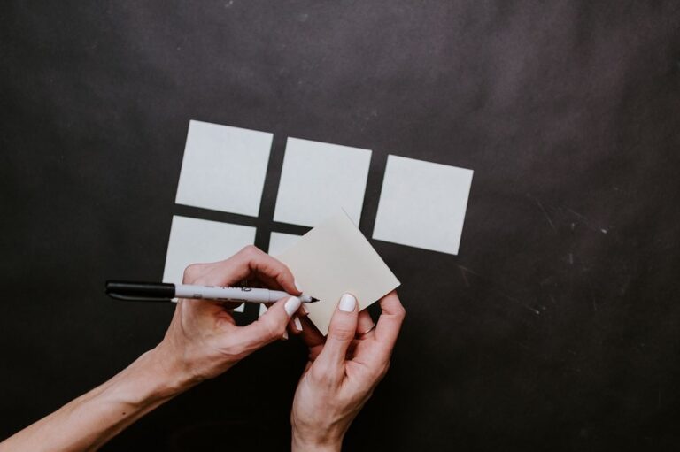 person writing out flashcards on a table