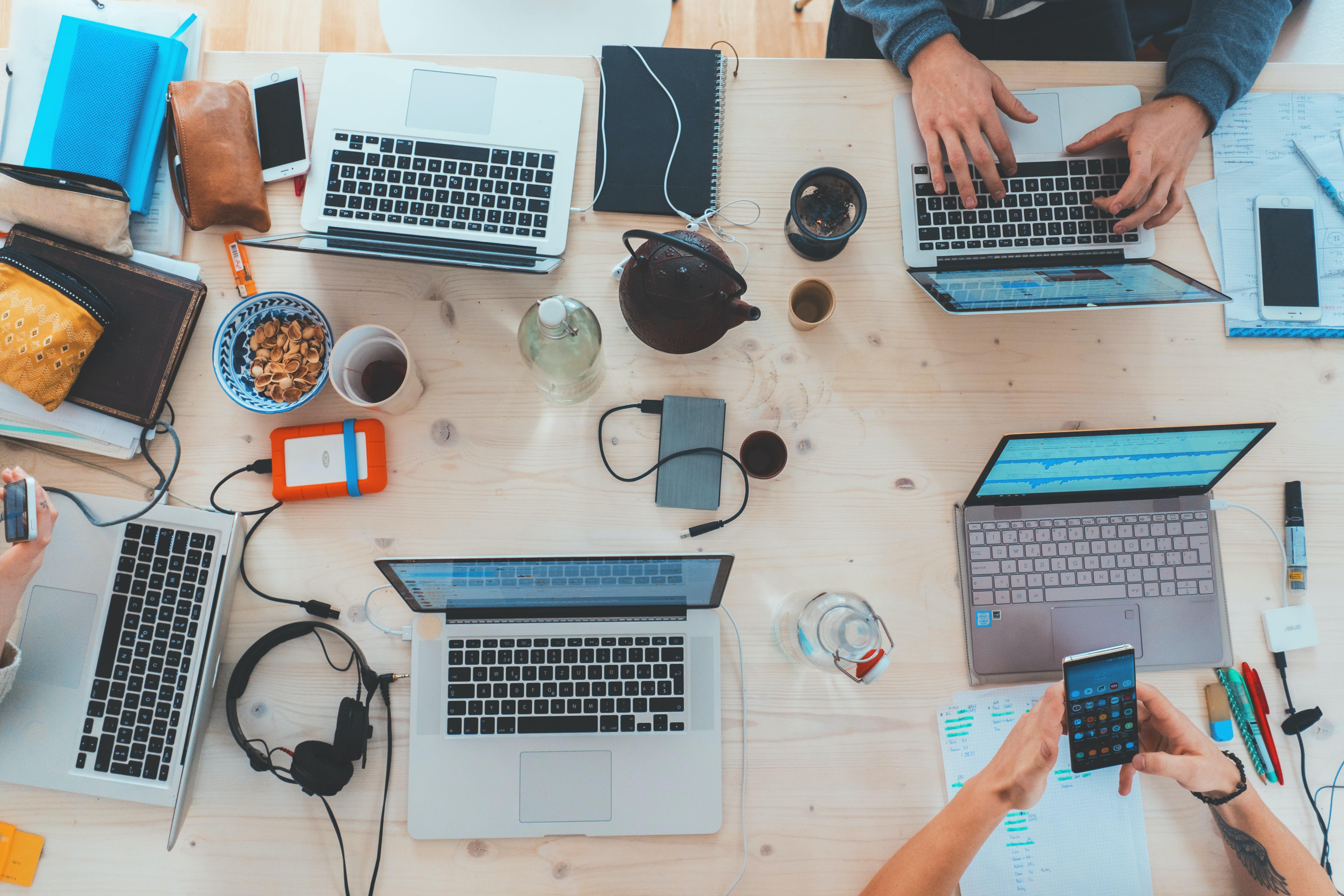 An array of laptops and smartphones on a desk