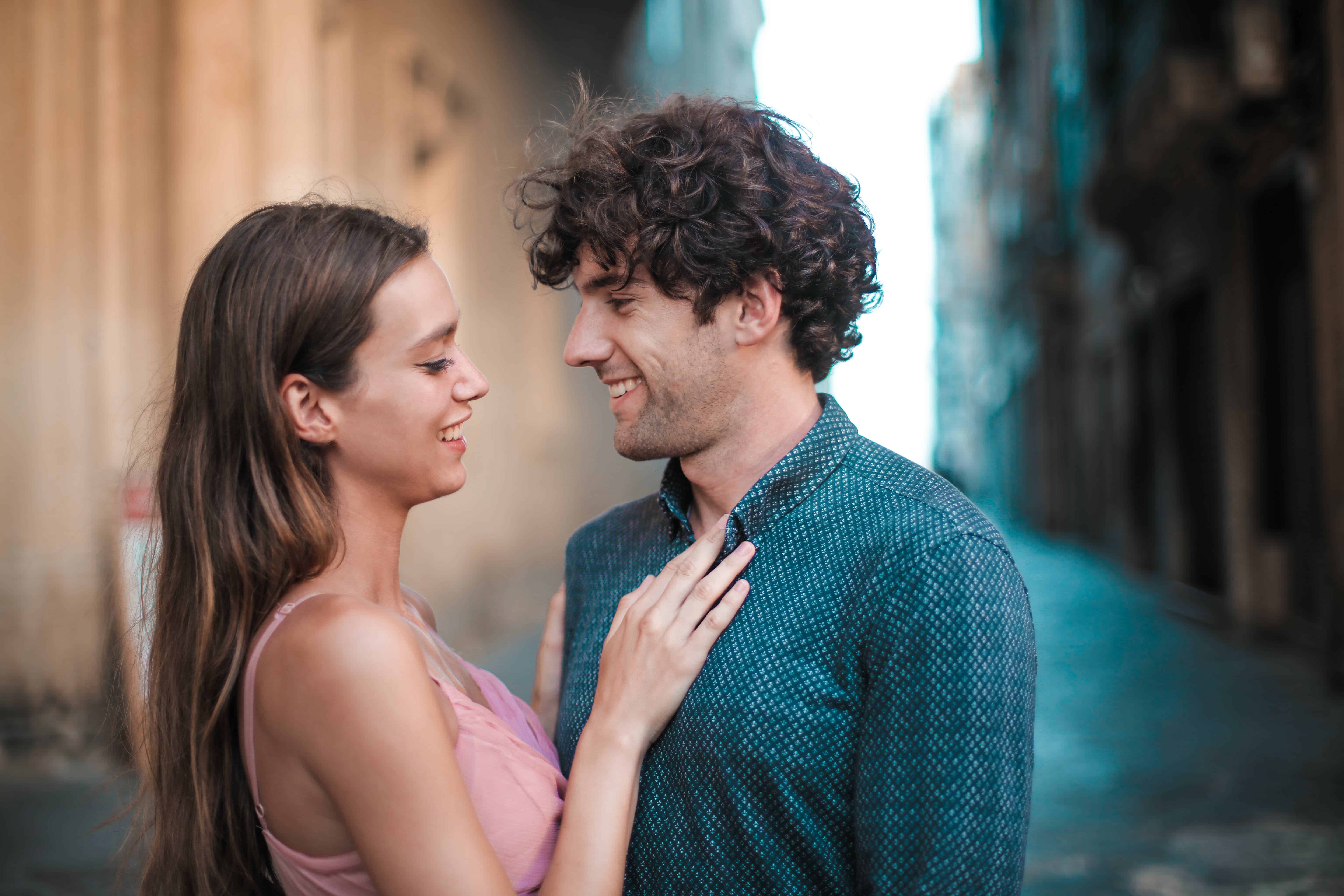 A couple flirts with one another on a European street