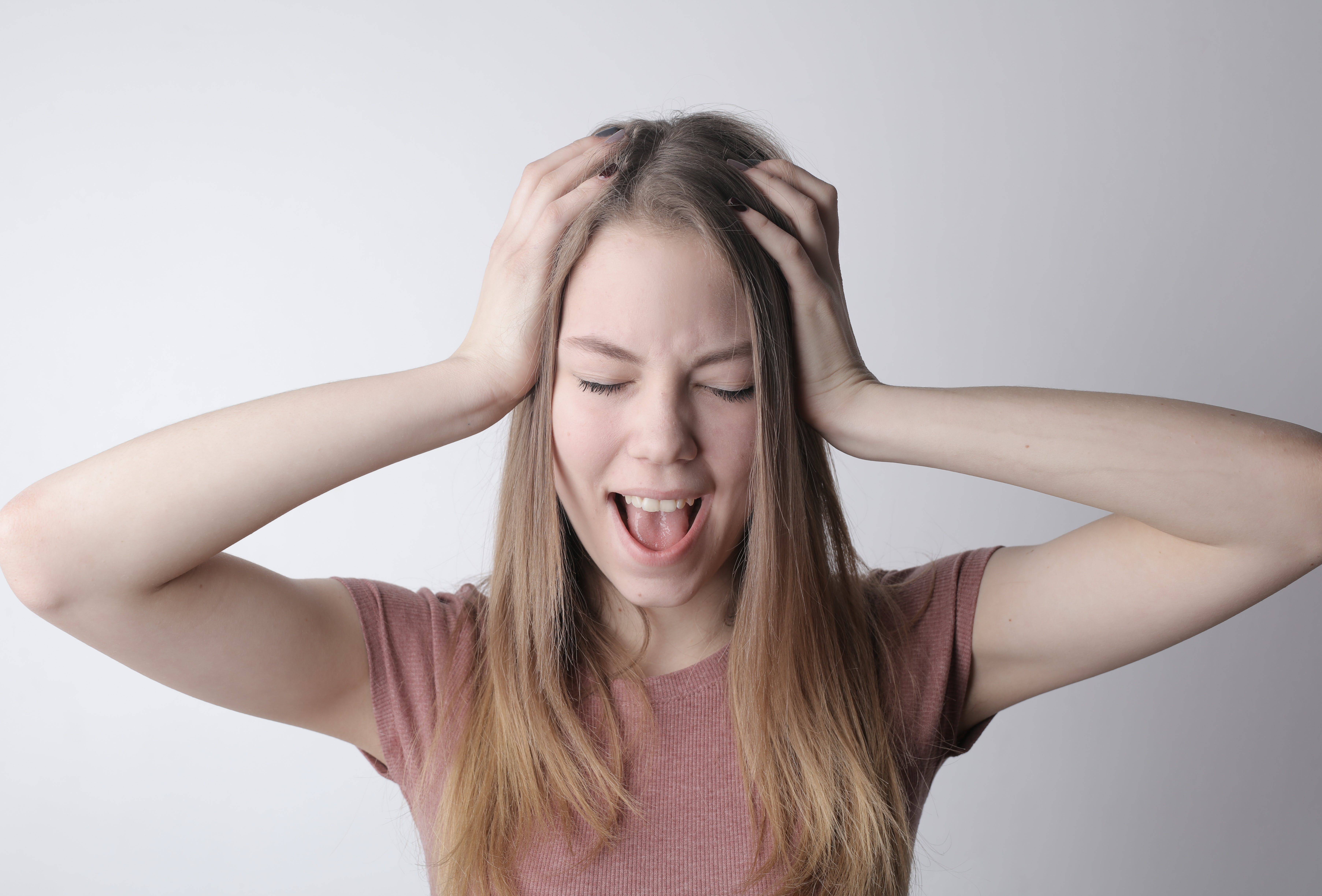 A woman holds her hands up to her head after making a mistake