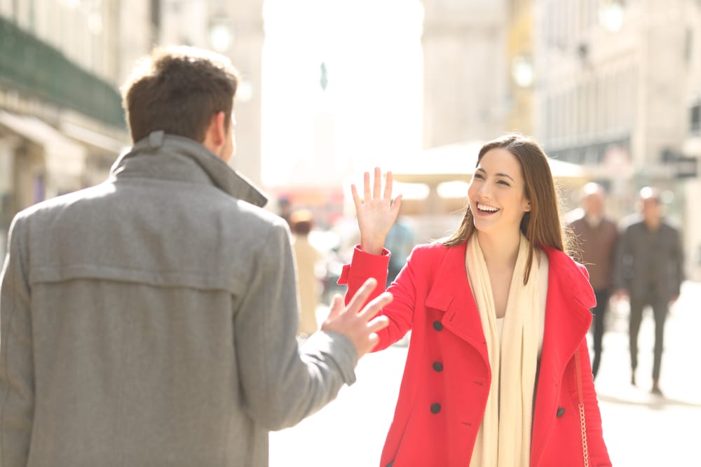 two friends greeting each other in a big city