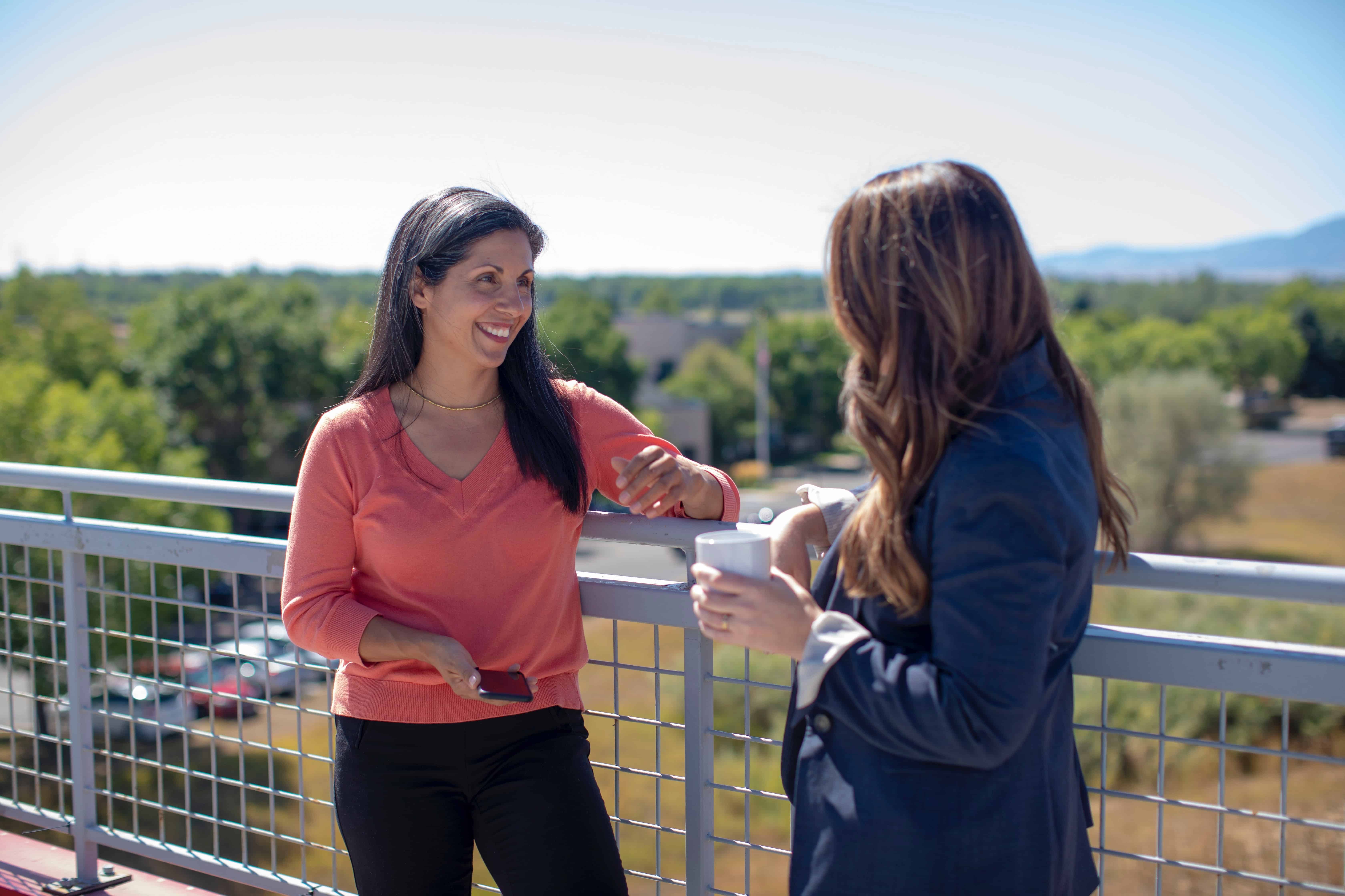 two women talking on a balcony