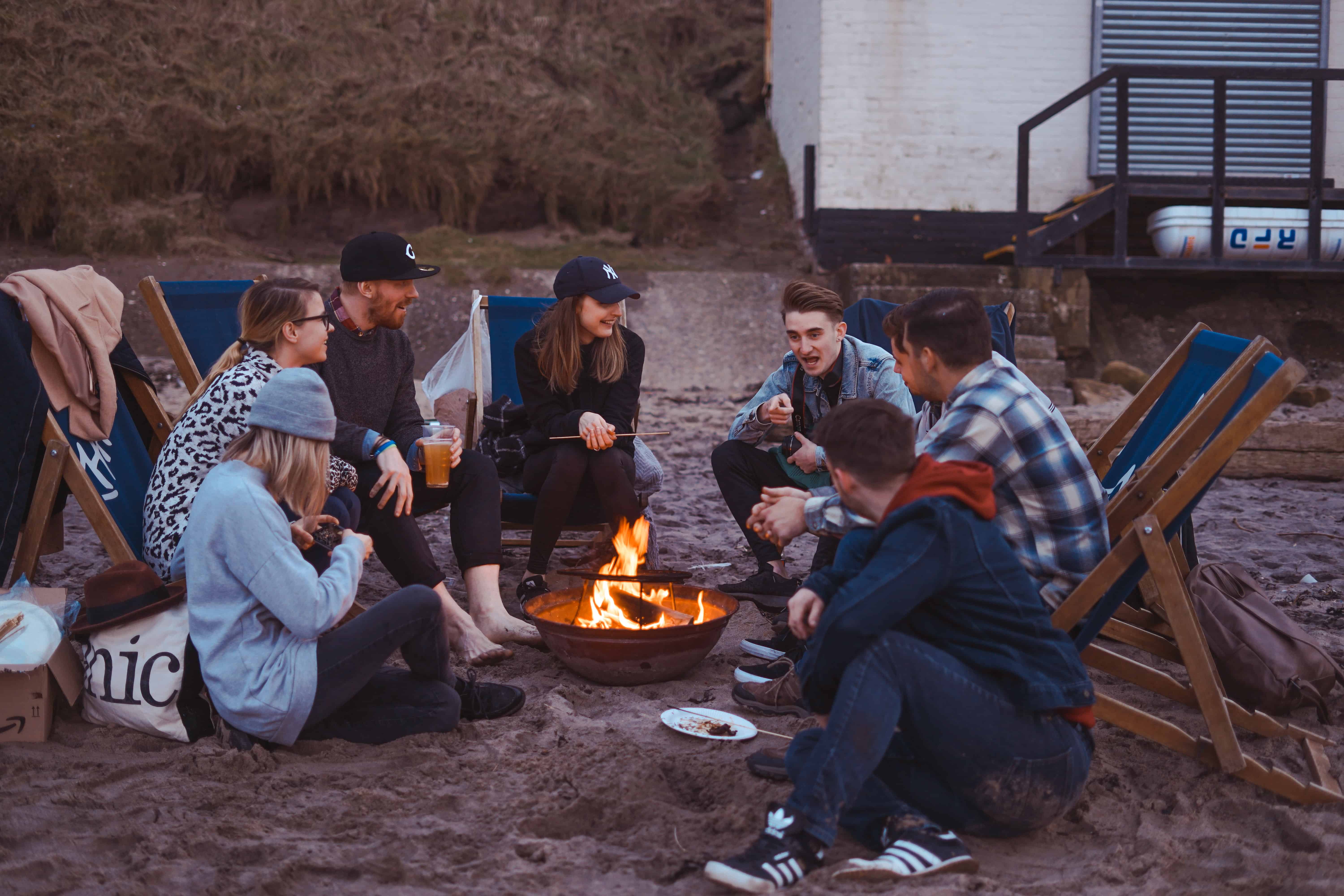 people sitting around a campfire