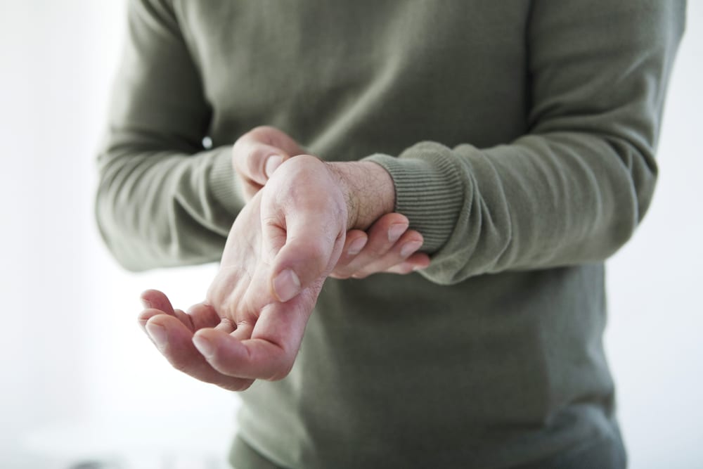 man holding his wrist because of carpal tunnel