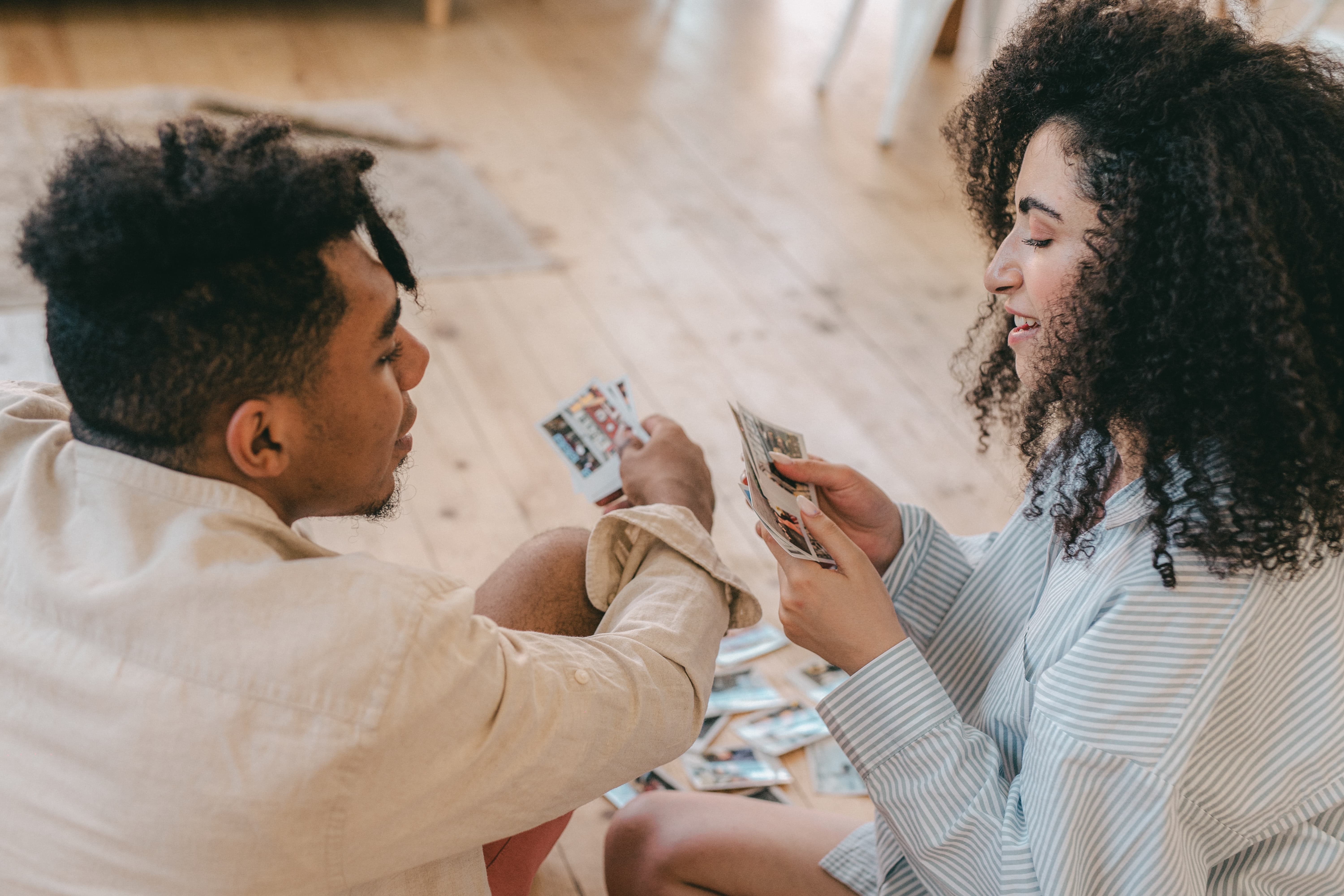 Two people facing each other holding cards