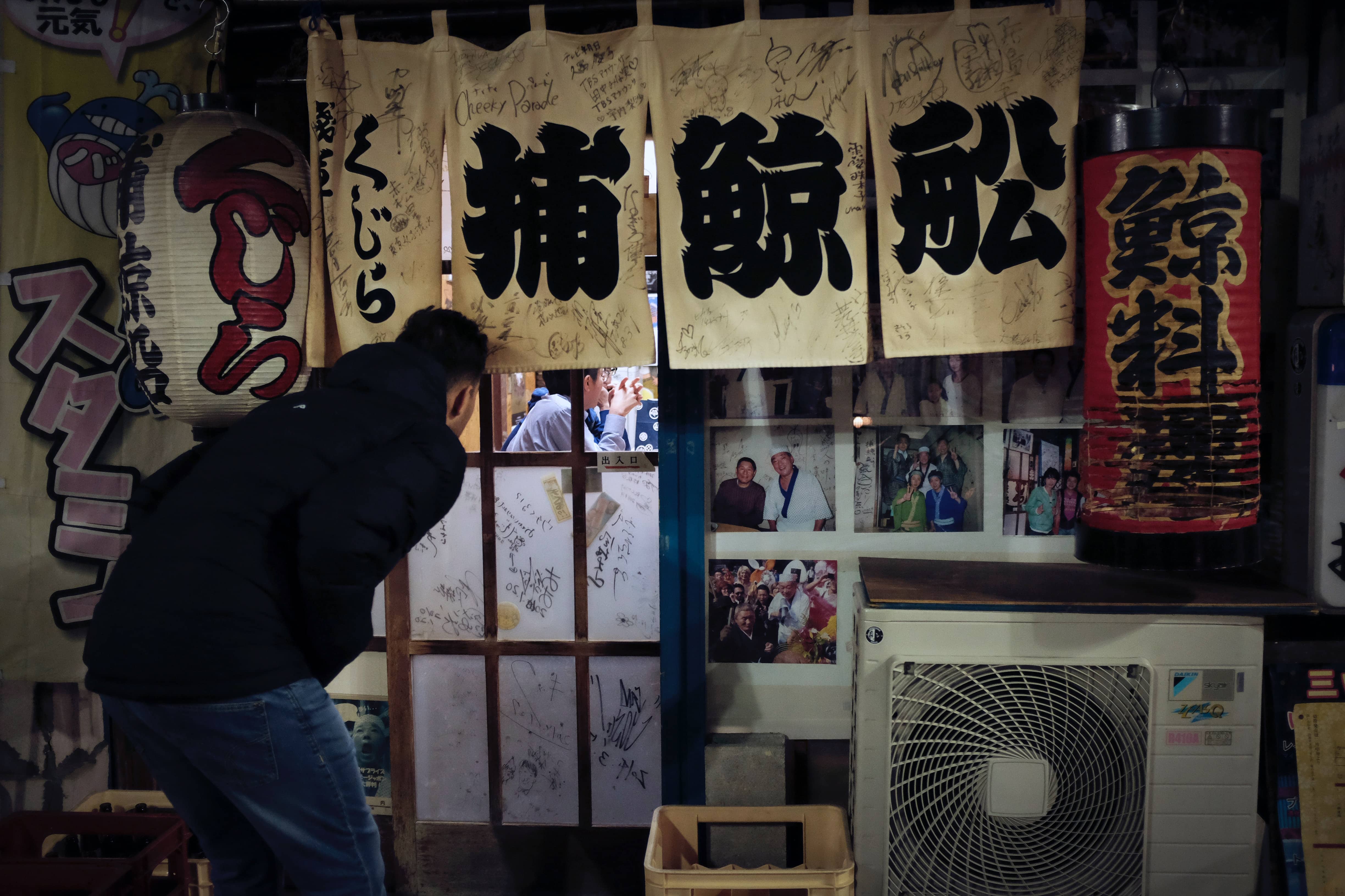 A Japanese person peers out a window