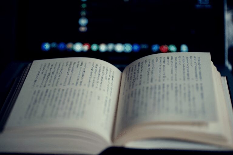 open book with japanese text in front of laptop computer