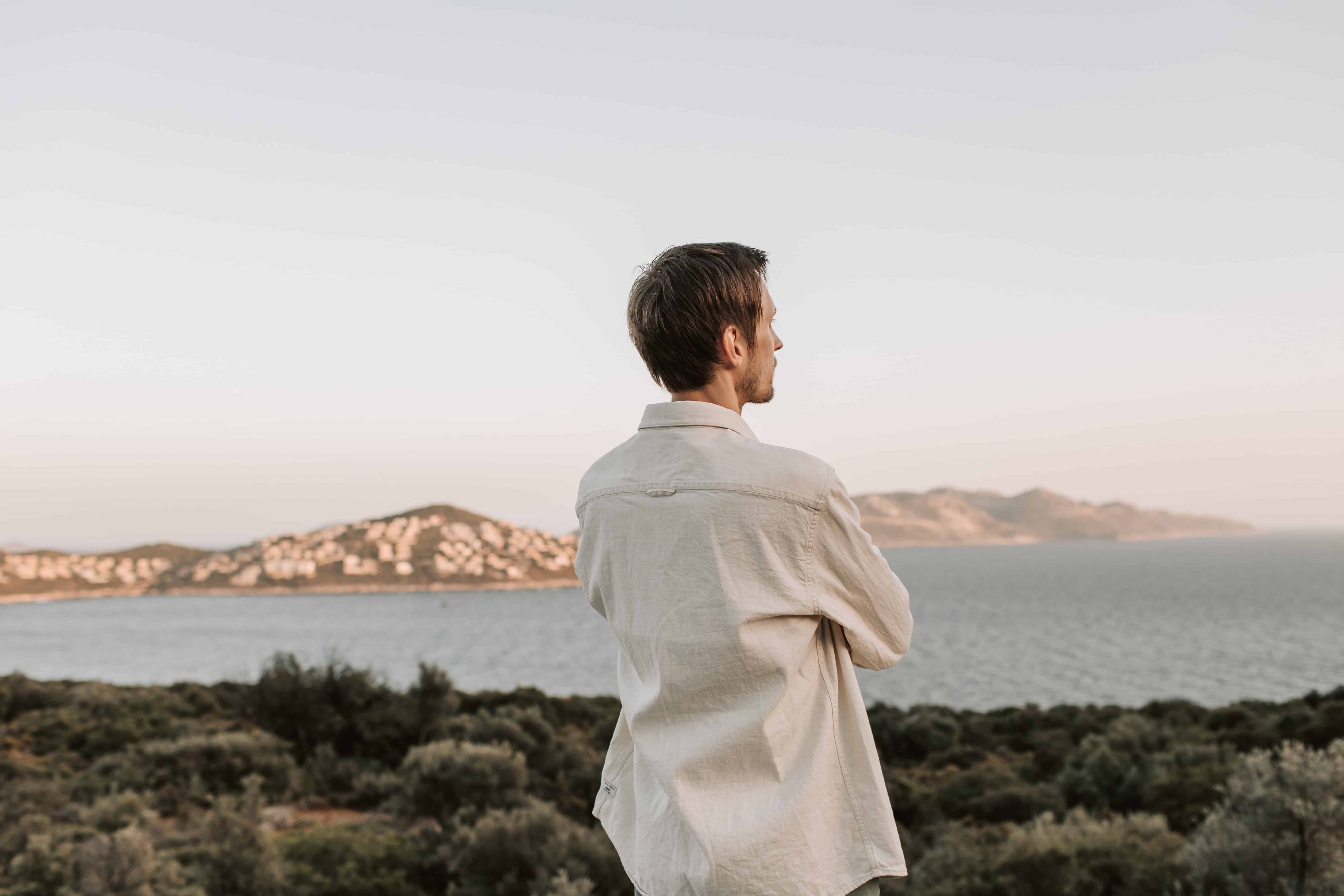 Man in white shirt staring out at the water